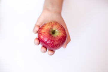 a hand holding a red apple