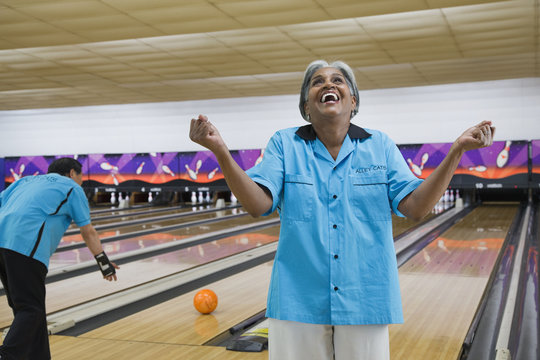 African woman cheering in bowling alley