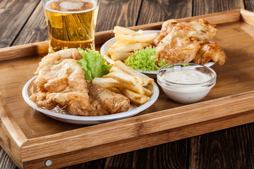Fish and chips with tartar sauce on a tray