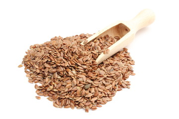 Heap of linseed with wooden spoon on white background