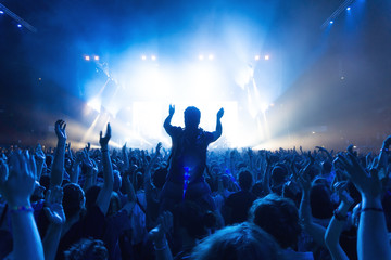 crowd of people at concert in front of the stage with lights