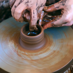 Hands working on pottery wheel