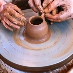 Hands working on pottery wheel