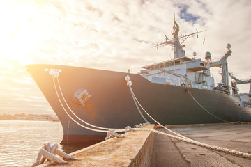 Naval auxiliary ship docked at the harbor.