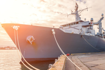 Naval auxiliary ship docked at the harbor.