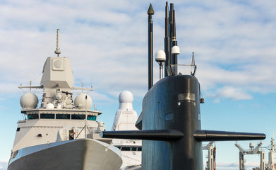 Naval fleet. Submarine and warships with guns.