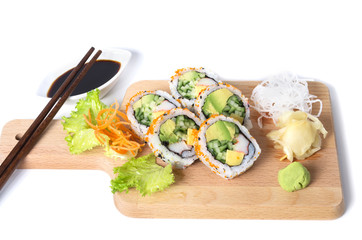 Set of California sushi rolls on a wooden board with chopsticks