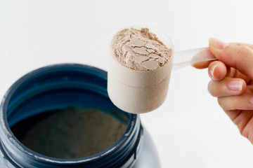 The hand raise a spoon measure Whey protein chocolate powder for
