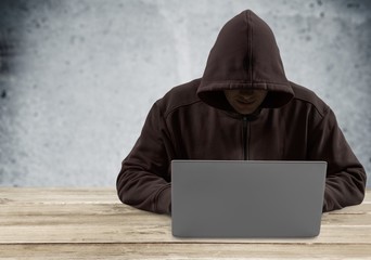 Theft. Hacker typing on a laptop with binary code in background