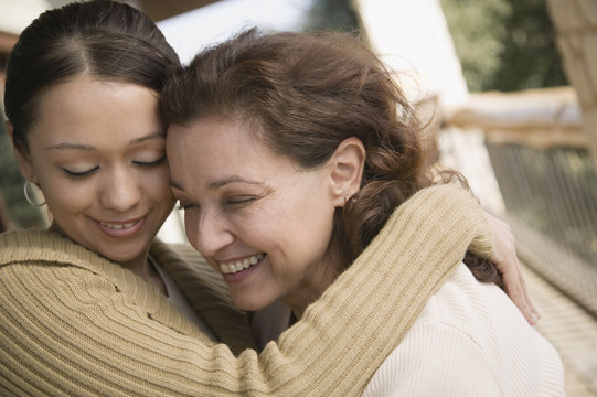 Multi-ethnic mother and daughter hugging