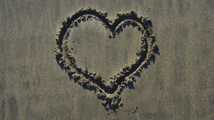 Heart draw on sand on a summer day
