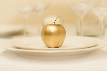 Golden apple on a white plate