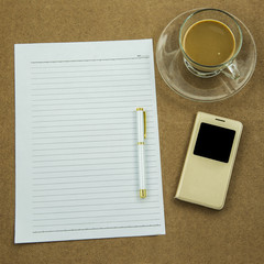 blank paper with smart phone pen and coffee cup on wooden table