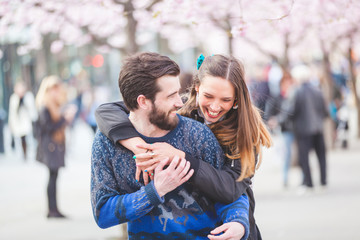 Happy hipster couple in Stockholm with cherry blossoms