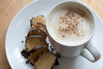 coffee with milk foam and cocoa to marzipan in chocolate
