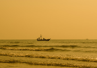 Fototapeta premium Silhouette of fisherman working on the boat. hua hin , Thailand.