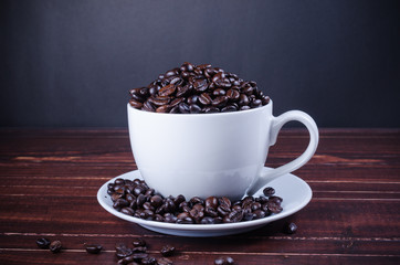 roasted coffee beans in coffee cup on wooden background