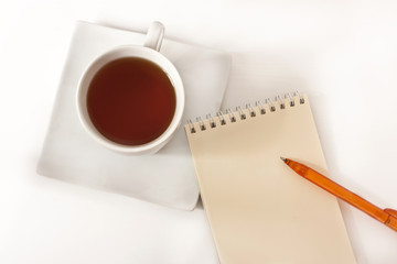Notepad bright pen and cup of tea with place for text