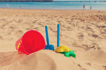 Fototapeta na wymiar beach toys in sand on sea shore