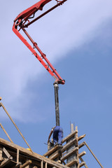 Builder worker with tube from truck mounted concrete pump