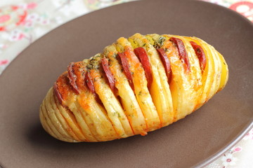 Hasselback potato with chorizo sausage and cheese