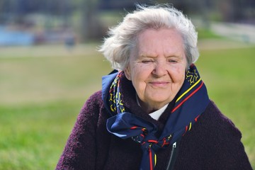 Senior woman smiling and dreaming in garden.