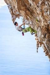 Rock climber on overhanging cliff, Kalymnos Island, Greece