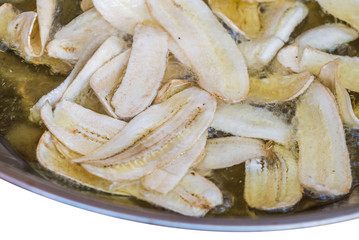 Sliced banana frying in hot oil