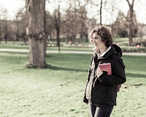 Young student holding books and walking around campus