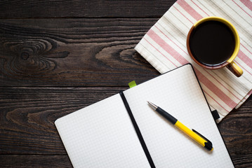 Notebook and a cup of coffee on the table
