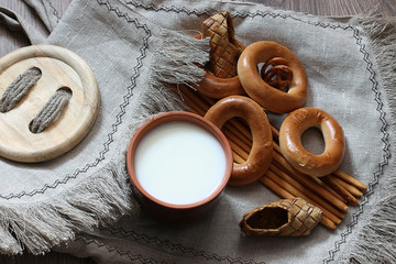 food milk in a glass straw bagels and pretzels on flax