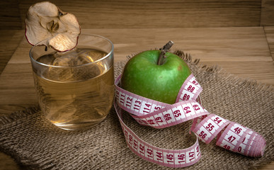 Apple juice with apples on wooden background