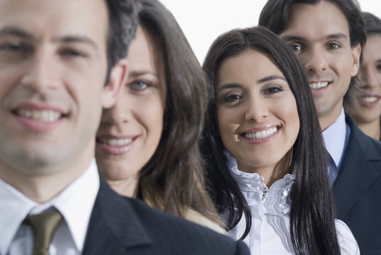 Hispanic co-workers standing in row