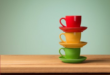 Cafe. Colorful coffee cups on wooden table over grunge