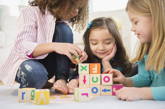 Girls playing with colorful blocks in living room