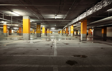 Image of parking garage underground interior, dark industrial bu