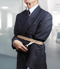 Image of businessman trying to get rid of fetters
