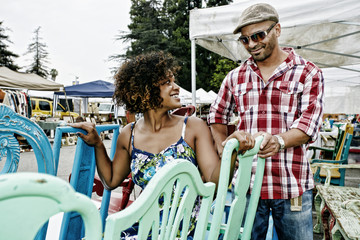 Couple buying colorful chairs at flea market