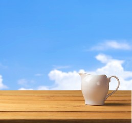 Dressing. White gravy boat on wooden table over grunge