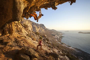 Foto op Plexiglas Young woman lead climbing along a roof in cave © Andrey Bandurenko