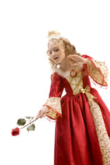 Beautiful little princess using red rose like a magic wand