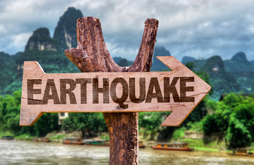 Earthquake wooden sign with countryside background