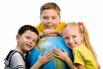 Three smiling children embracing the globe.
