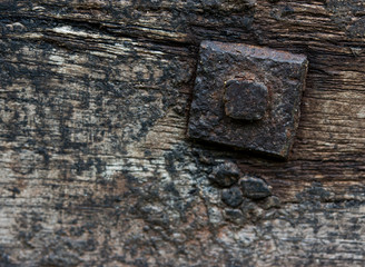 Nut and bolt on a wooden background. Close up detail.