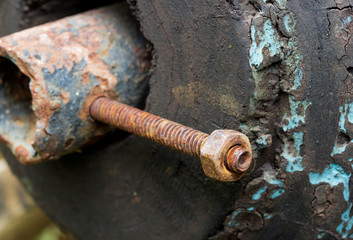 Nut and bolt on a wooden background. Close up detail.