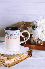 Old wooden suitcase with old books and flowers on wooden background