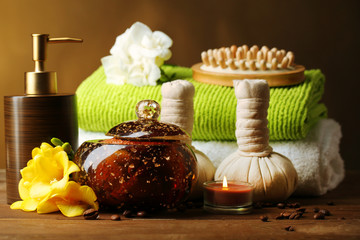 Composition of spa treatment on wooden table, on dark color background