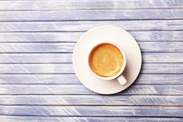 Cup of coffee on wooden table, top view