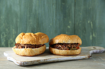 Tasty sandwich on cutting board, on color wooden background. Unhealthy food concept