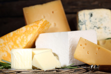 Different sort of cheese on wicker tray, closeup
